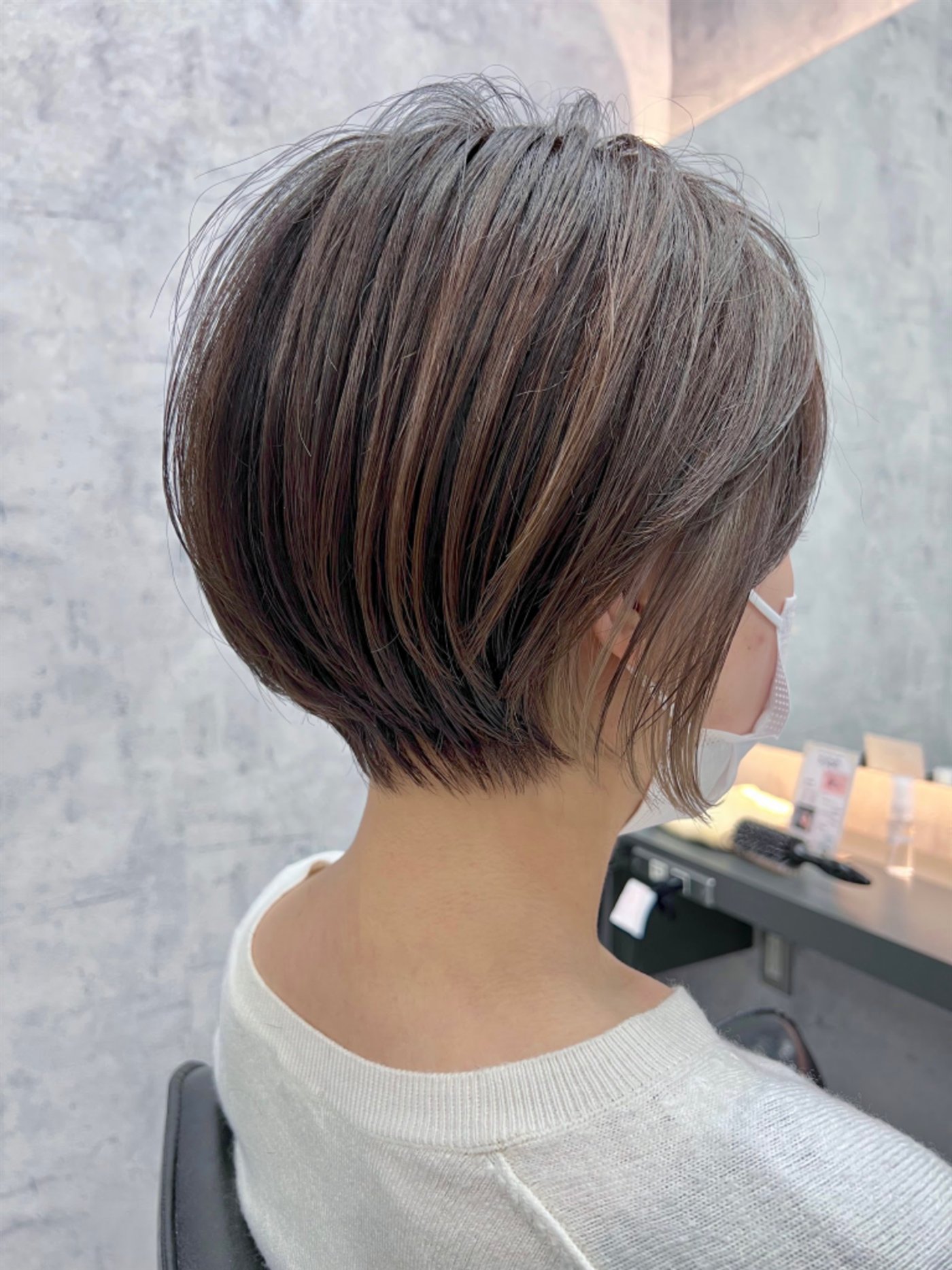 細かなハイライトと丸みのあるシルエットを合わせた大人ショートボブの後ろ姿