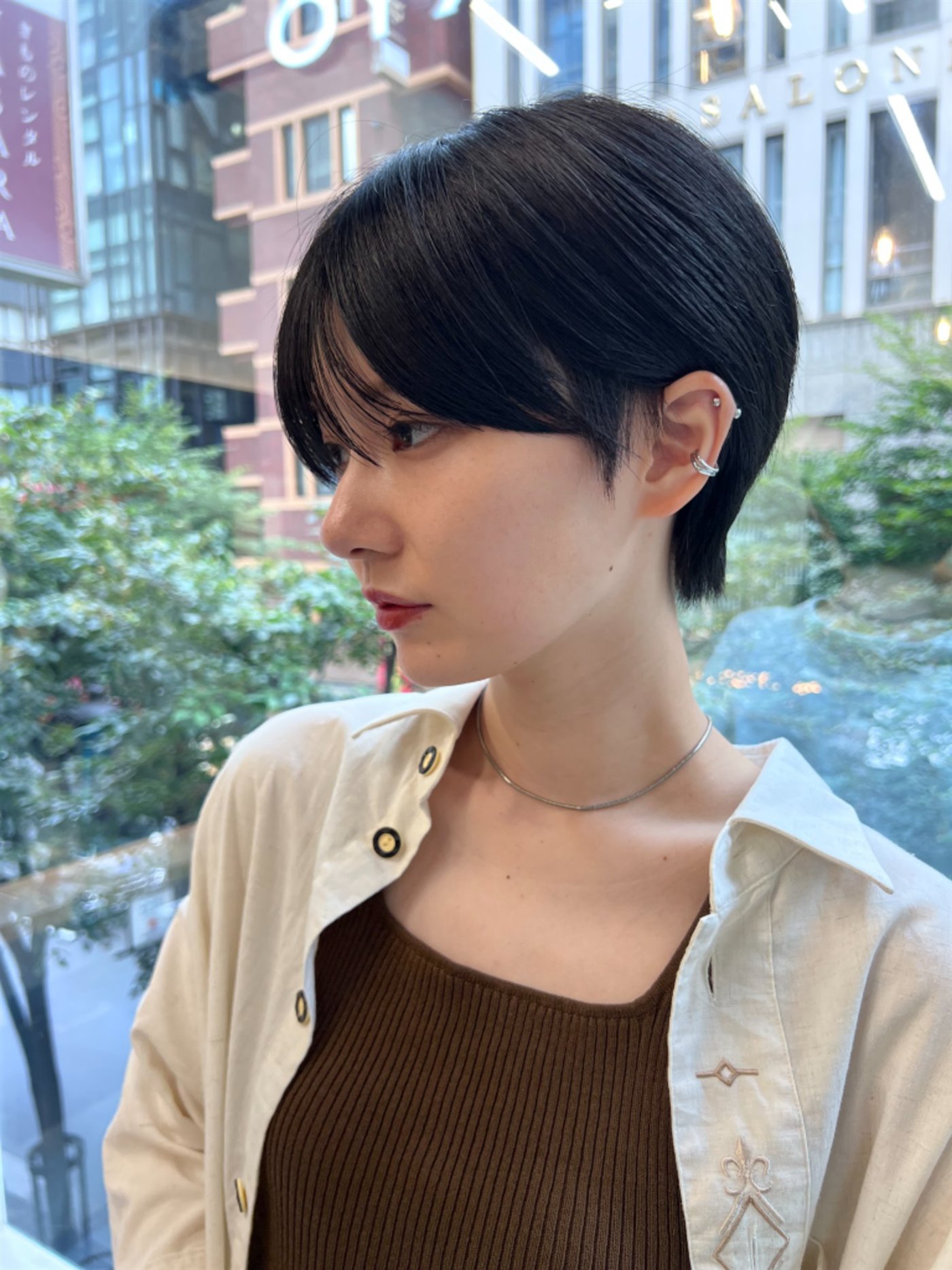タイトな襟足と長めの前髪を合わせた黒髪の骨格補正ショート
